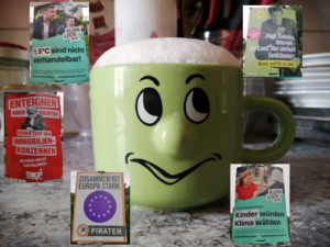 Auf dem Bild ist eine Tasse mit Gesicht zu sehen und fünf verschiedene Wahlplakate