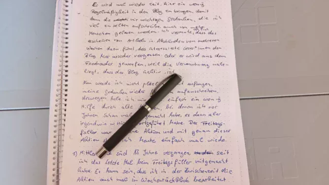 Auf dem Bild liegt ein schwarzer Füller auf einem beschriebenen Blatt Papier in der Größe A4.